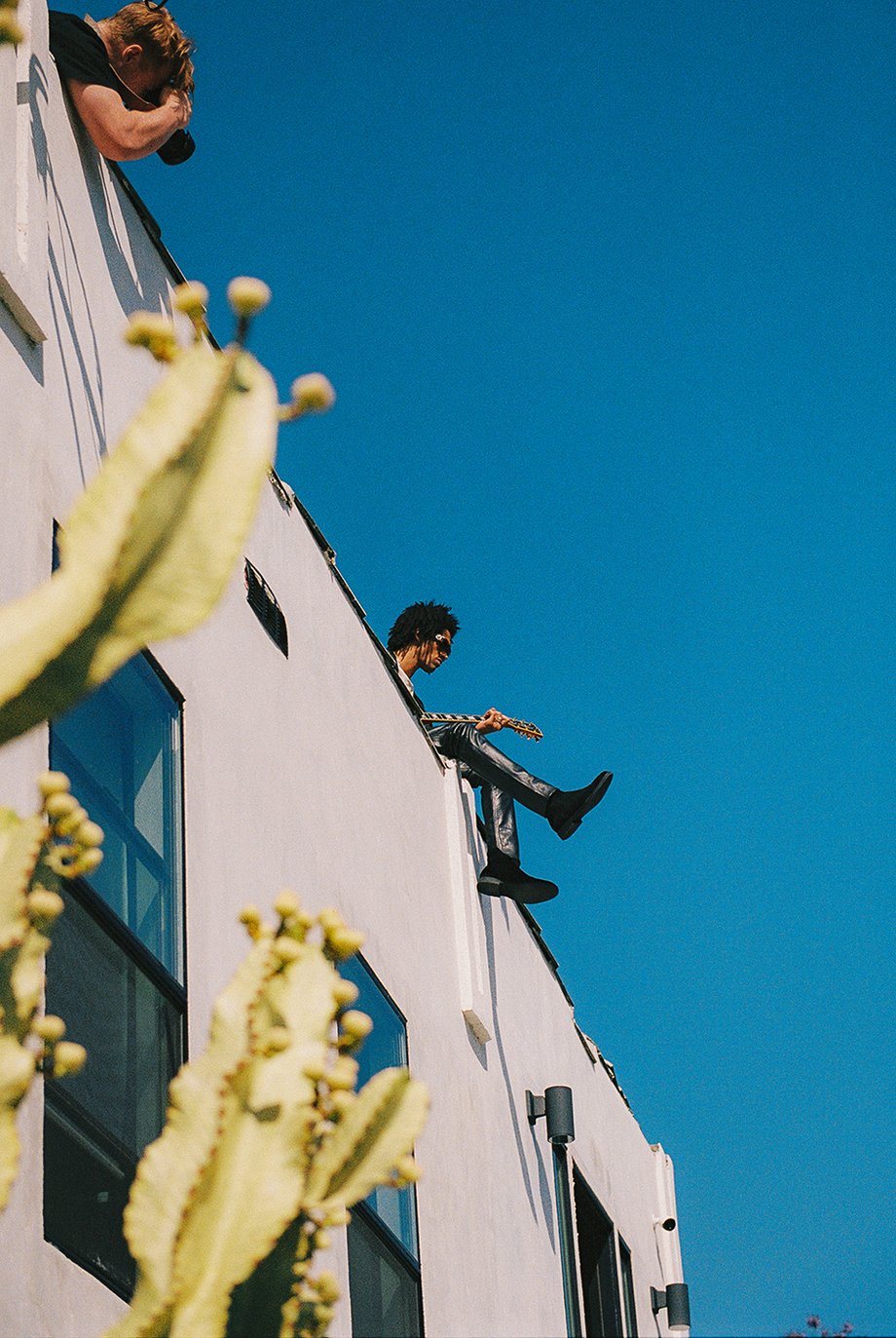 Model Jaxon Rose playing guitar on roof shot from below by Michael Julius for New Republic