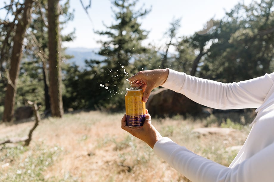A can of Spectro Hazy IPA being opened while camping. Photographed by Mikaela Hamilton for Topa Topa Brewing.