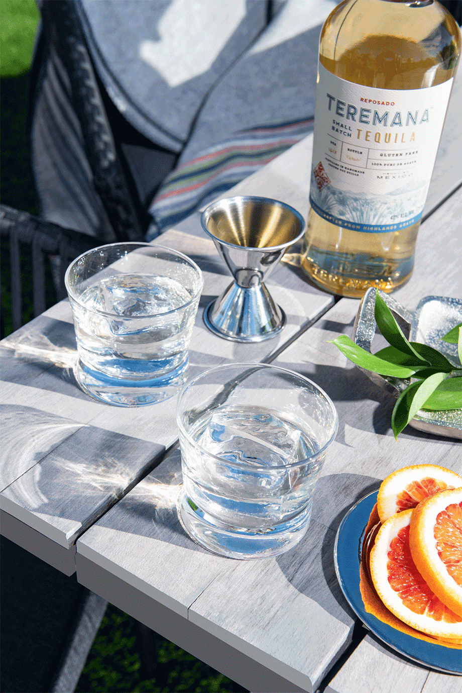 Gif of two empty glasses filling with Teremana tequila with citrus and garnish 