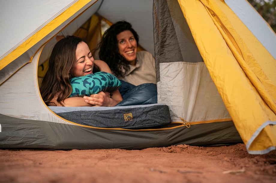 Two women rest on Hest mattress inside tent in Moab desert shot by Motofish