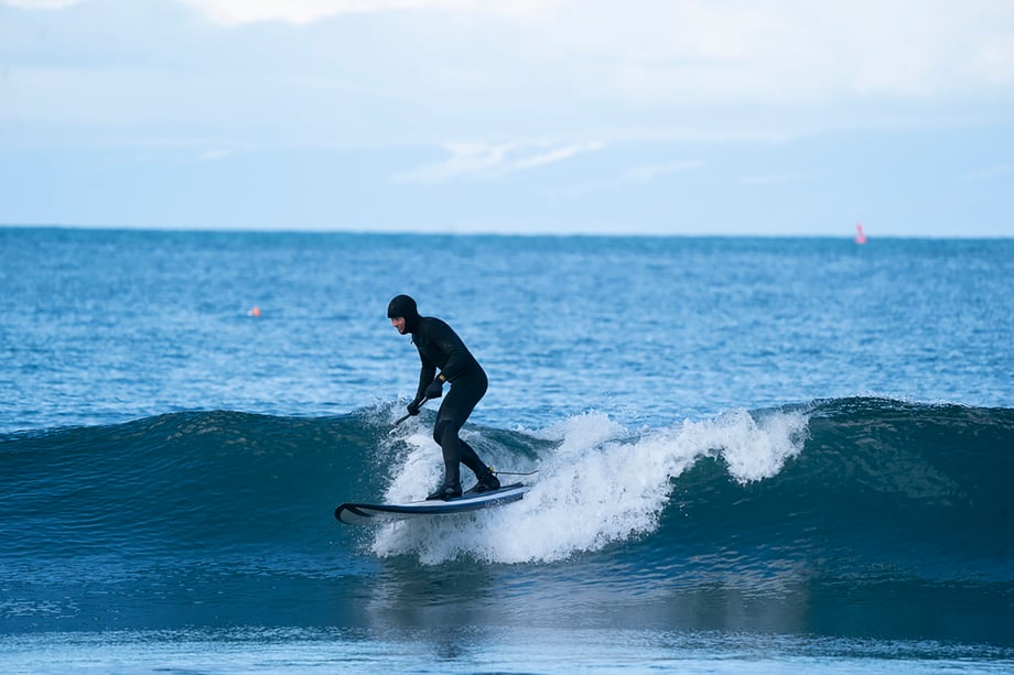 Man in wetsuit surfing on Washington coast shot by Motofish for Hest