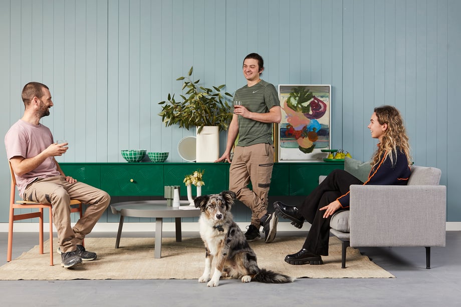The Ensemble design team posing as subjects with an Australian Shepard in front shot by Peter Tarasiuk