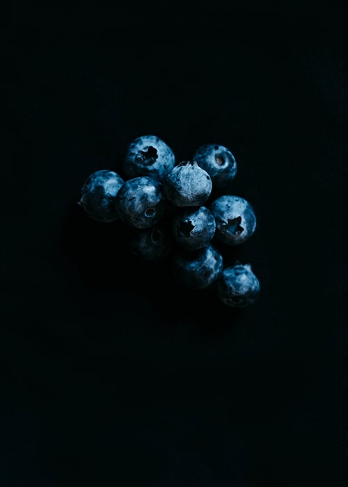 Blueberries photographed against a black background