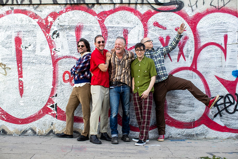 Members of the band Weezer pose against a wall covered in graffiti on the streets of Los Angeles. Photographed by Sean Murphy. 