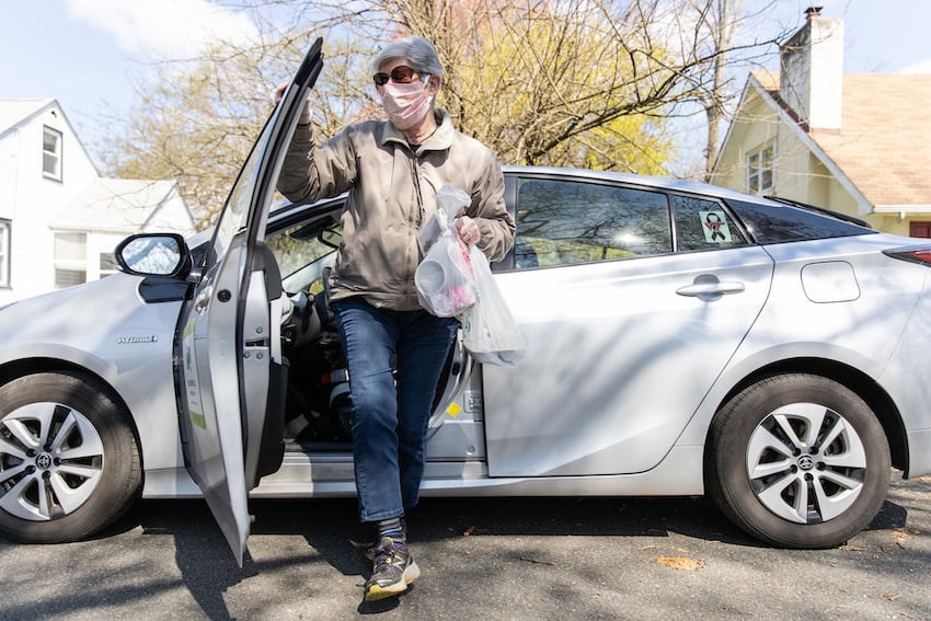 Photo by Colin Lenton of a Meals on Wheels volunteer arriving at a recipients house.