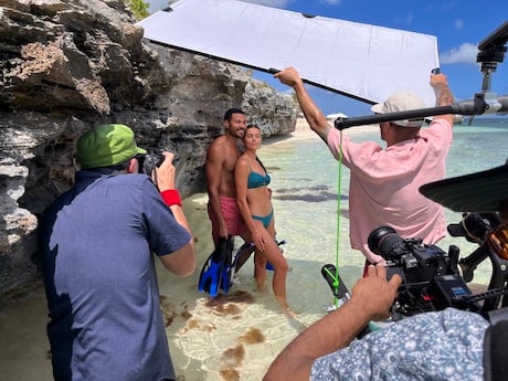 Bryce Boyer and team wade in crystal blue waters to capture the rocky shore line in Turks and Caicos for Leading Hotels of the World.