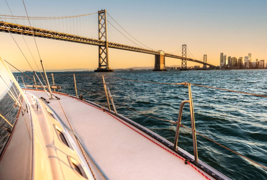 A boat riding under the San Francisco Bay Bridge by Jayms Ramirez