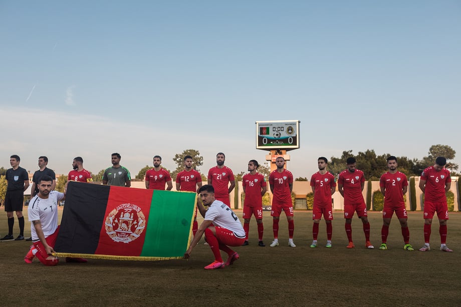 The Afghanistan National Soccer team carry the pre-Taliban Afghan flag onto the pitch during their national anthem, before their match against Indonesia. Shot by Bradley Secker for the New York Times.