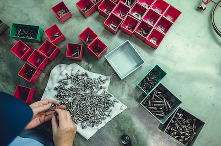 Person organizes nuts, bolts, etc. in an industrial setting, captured by Tokyo-based photographer Irwin Wong