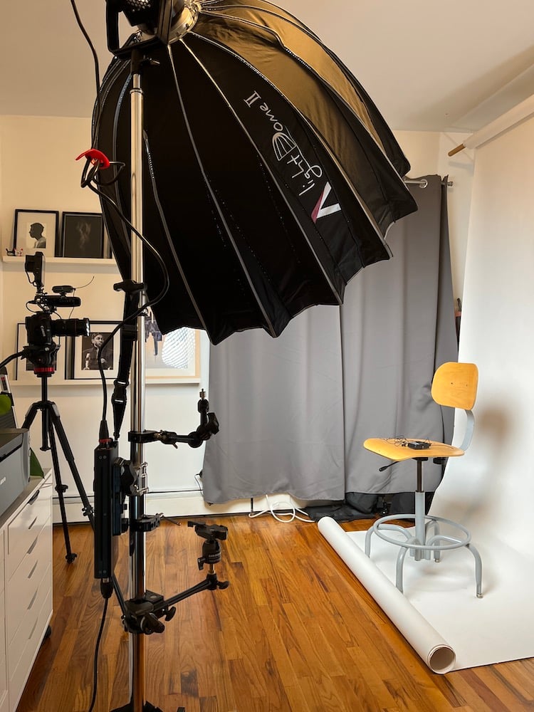 Behind-the-scenes photo of interview set with lights, camera, chair, and backdrop, by Brooklyn-based music/performing arts photographer Dan Robinson. 