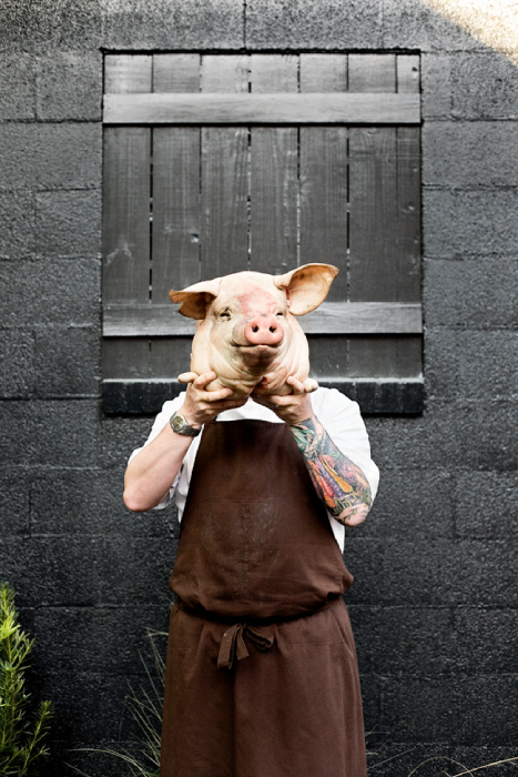 Sean Brock holding a pig's head over his face shot by Charleston, S.C.-based food and portrait photographer Christopher Shane