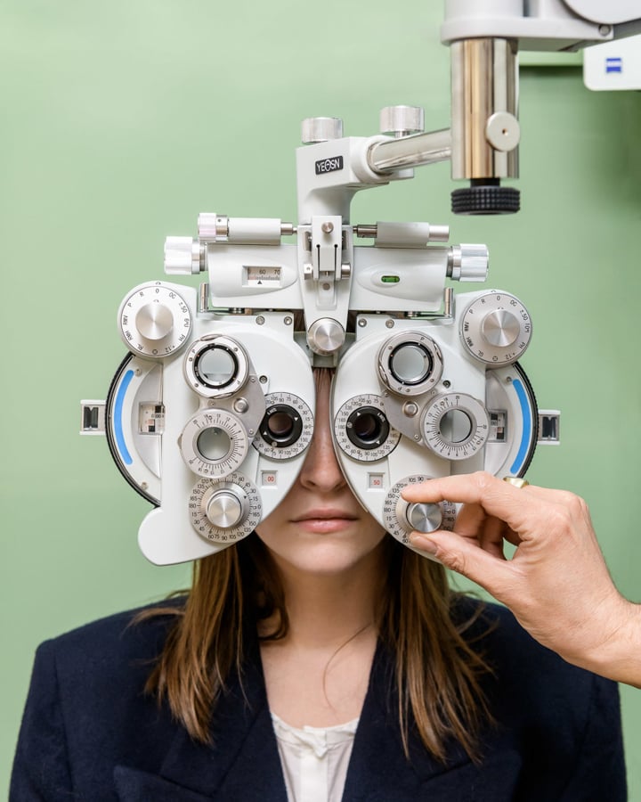 A woman looks through an eye exam machine by photographer Alastair Philip Wiper of Copenhagen, Denmark 