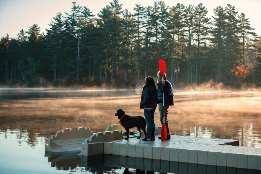 Image of two figures with a kayak paddle and dog beside a steaming lake by Reisterstown, Maryland-based photographer Clark Vandergrift.