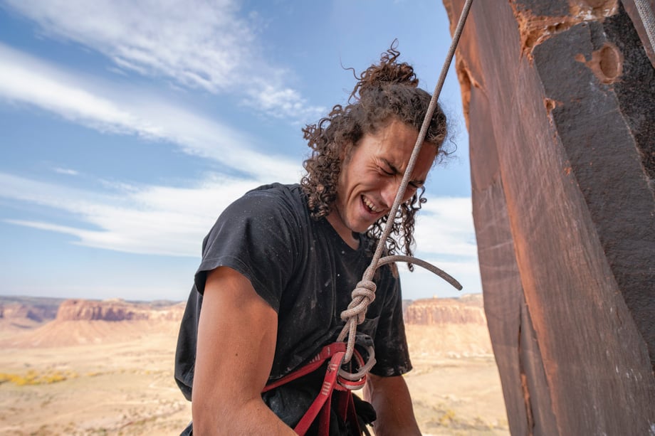 Dalton Johnson photographs laughing rock climber harnessed for Gregory Packs and Coalatree