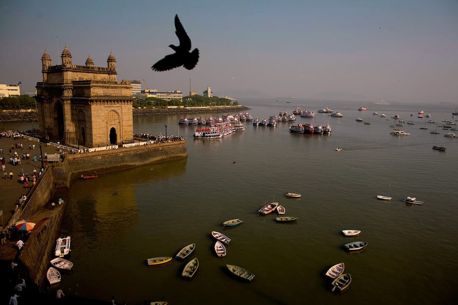 Photo by Darren Hauck of a pigeon seen as it flies above the Gate Way to India as seen out of the Taj Mahal hotel Mumbai India.