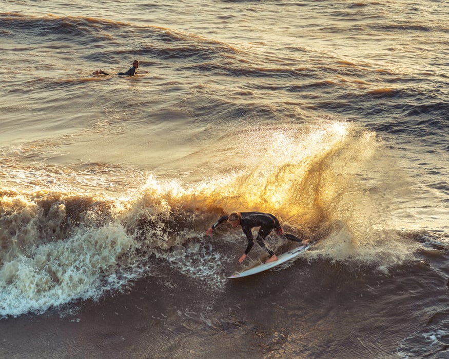Person surfing on wave by Atlanta fitness/sports photographer Daryl Spiegel 