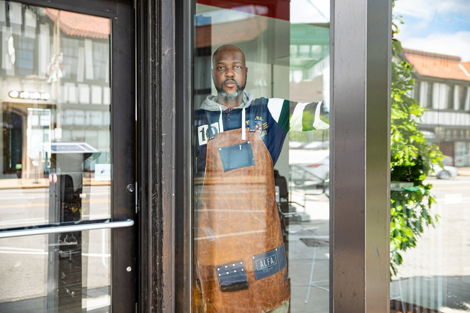 Lou Bopp captures a photo of a man in a leather apron in a storefront window for CBS Sunday Morning 
