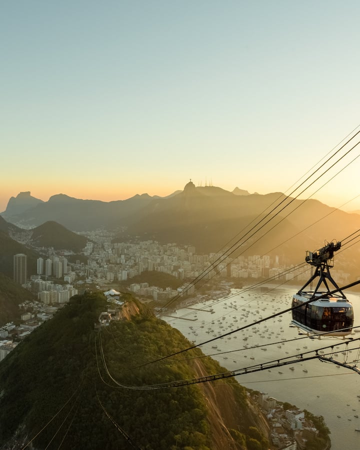 A peek of Rio de Janeiro, Brazil from a mountain top at sunset, with Christ the Redeemer far off in the distance by photographer Fernando Veloso Leão of Rio de Janerio, Brazil. 