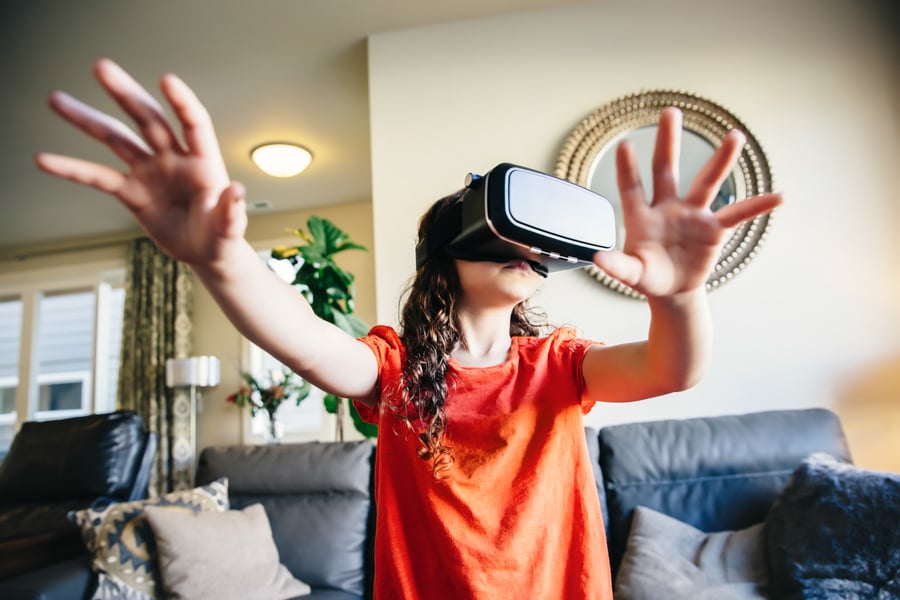 A young girl reaches out as she wears a VR headset by photographer Inti St. Clair