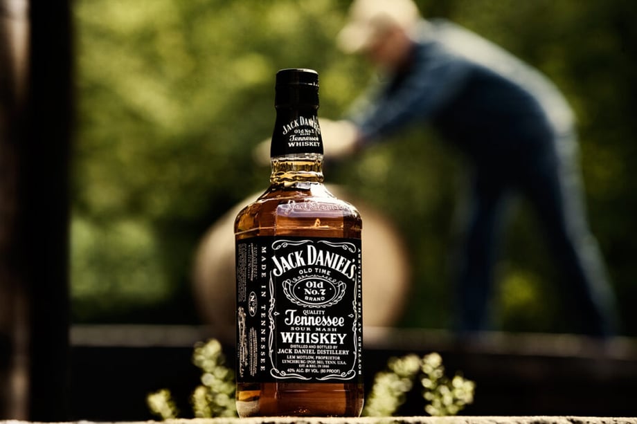 A whiskey distiller bushes a barrel behind a bottle of Jack Daniels by Mark Katzman of St. Louis, Missouri