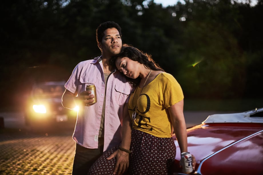 Jay Fram captures a couple leaning on one another, beers in hand, in front of a red convertible