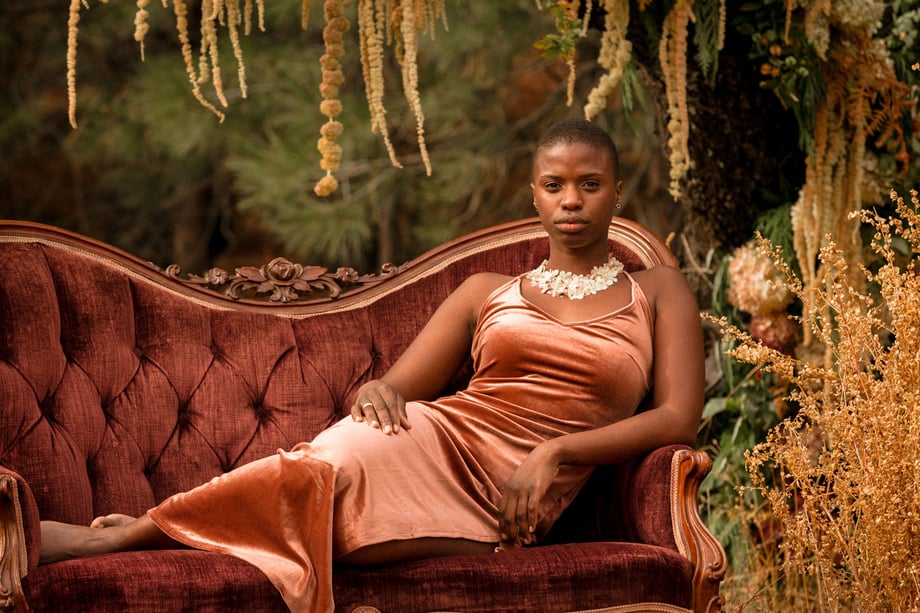 Jesse Cornelius's image of a Black woman reclining on an old fancy couch in an outdoor setting for Solmonson farms