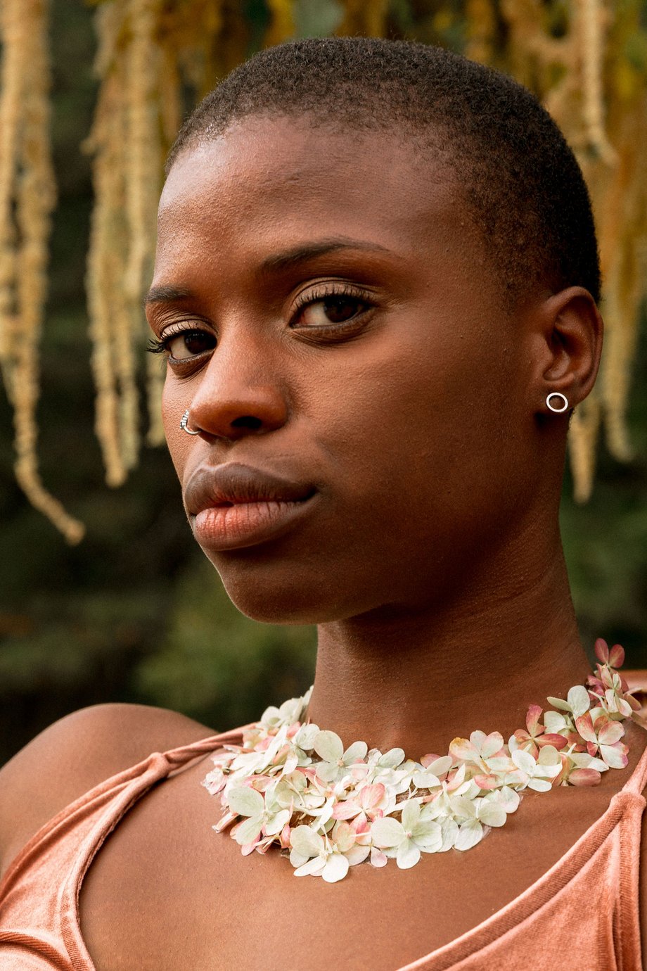 Jesse Cornelius's close up image of a Black woman with flowers for Solmonson Farm