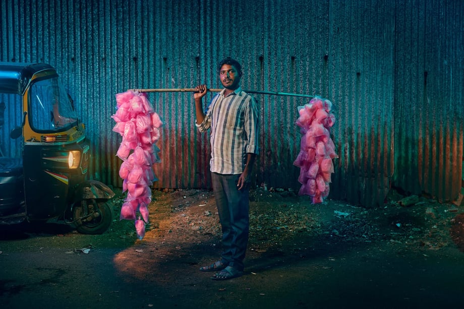 Image of candy floss vendor standing on Mumbai street at nighttime by London-based portrait photographer Jon Enoch.