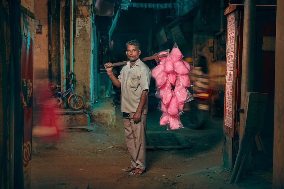 Image of candy floss vendor holding his product on a stick over his shoulder by London-based portrait photographer Jon Enoch.