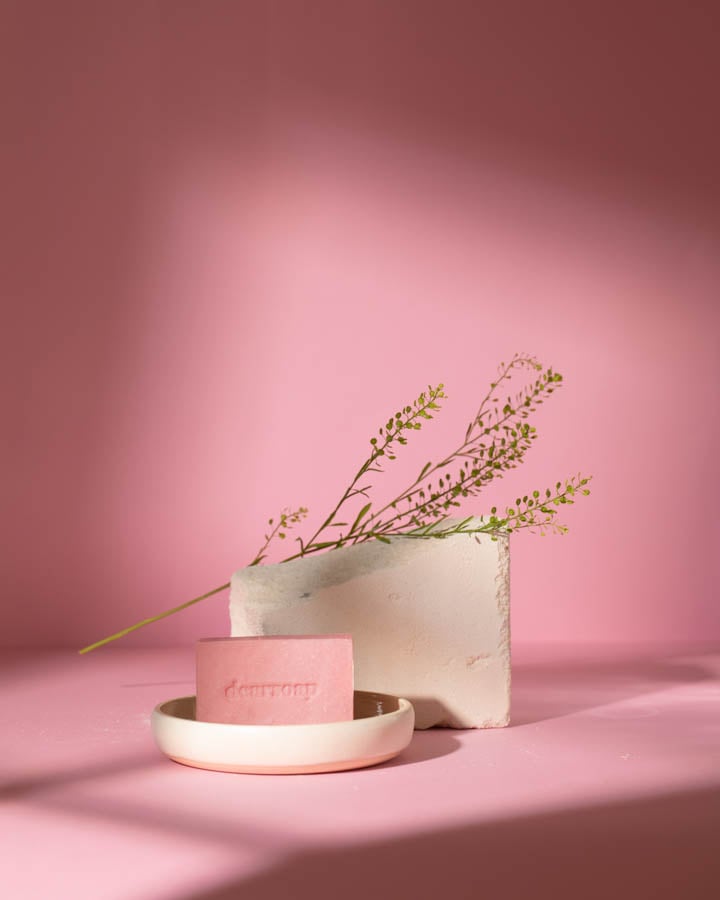 Pink soap staged in front of some of its ingredients on a pink backdrop by photographer Jordanna Schramm of Berlin, Germany