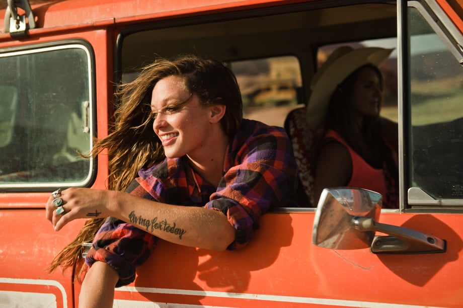 Photo by Josh Letchworth of a woman smiling and leaning out of a jeep's passenger seat.