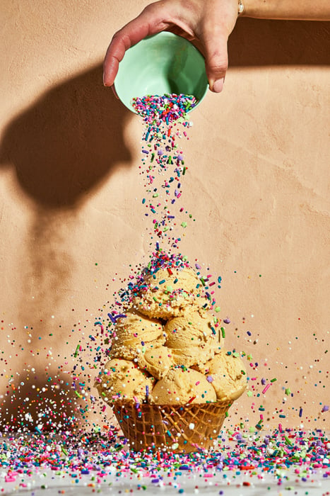 Photo of a hand dropping sprinkles over ice cream scoops taken by Washington DC-based food photographer Justin Tsucalas of Plaid Photo. 