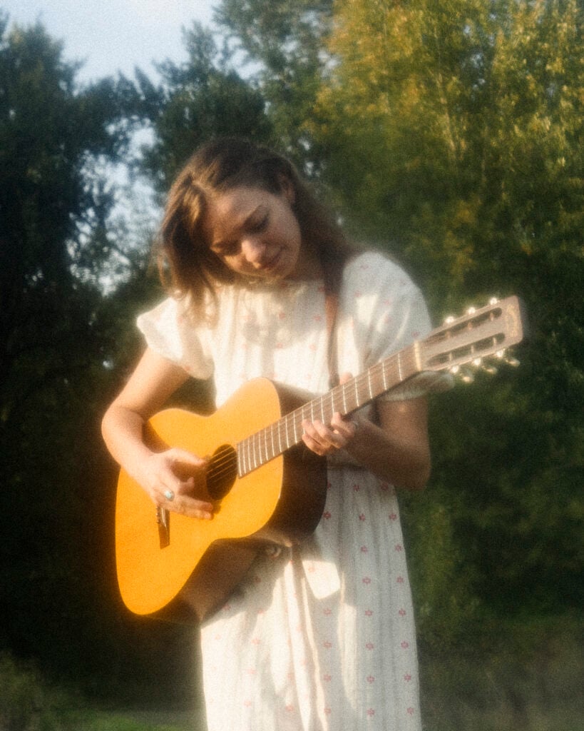 Woman in long white dress plays acoustic guitar in the woods. Creative in Place Carry a Tune photographer Molly Strohl, Portland, Oregon