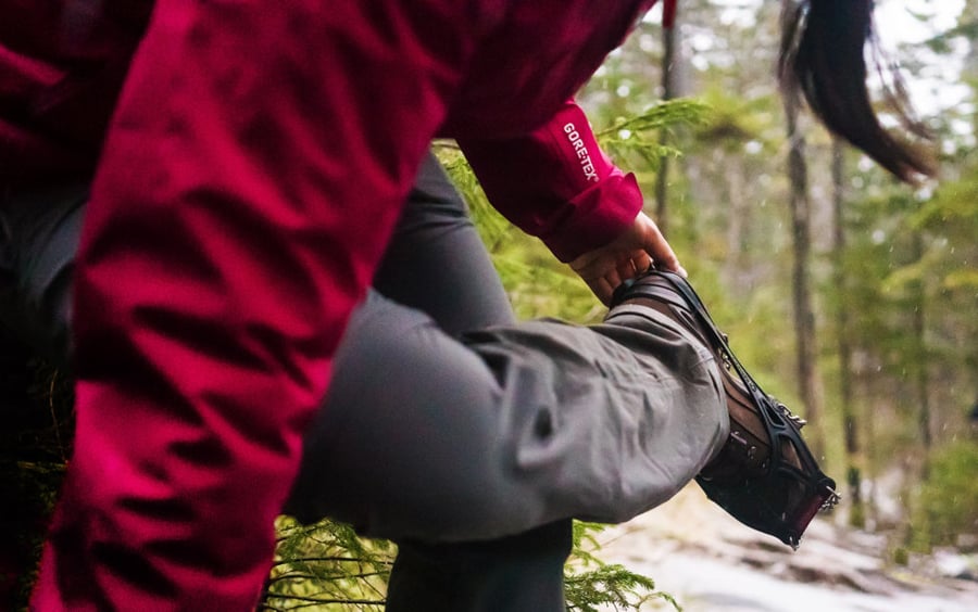 Photo of a hiker adjusting boot spikes by Boston, Massachusetts-based photographer Nicole Loeb.