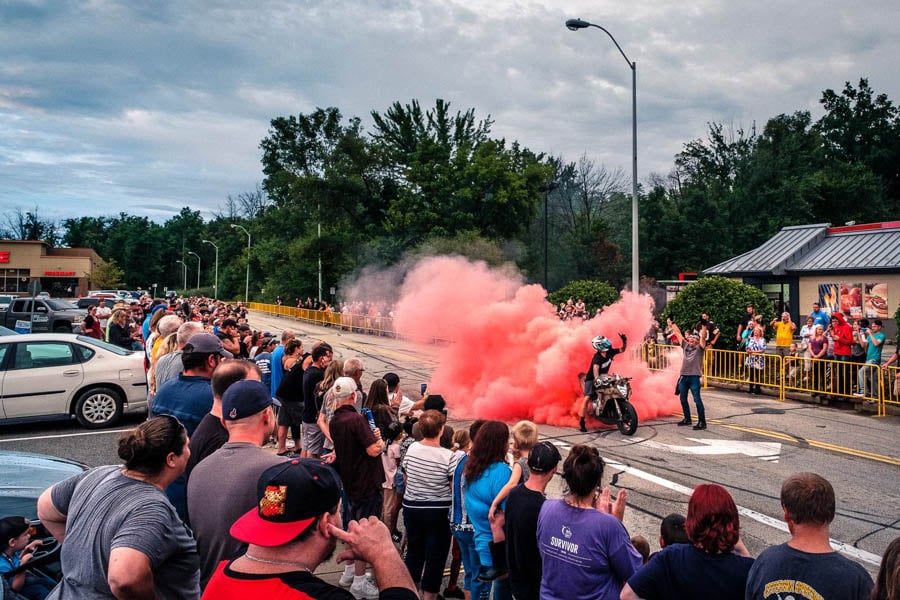 A motorcyclist blows pink smoke as a crowd watchs from a distanc by photographer Patrick Cavan Brown of Arvada, Colorado. 