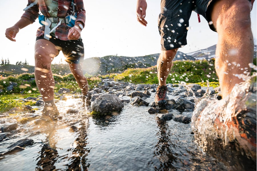 Image of hikers splashing through a stream by Seattle, Washington-based photographer Stephen Matera.
