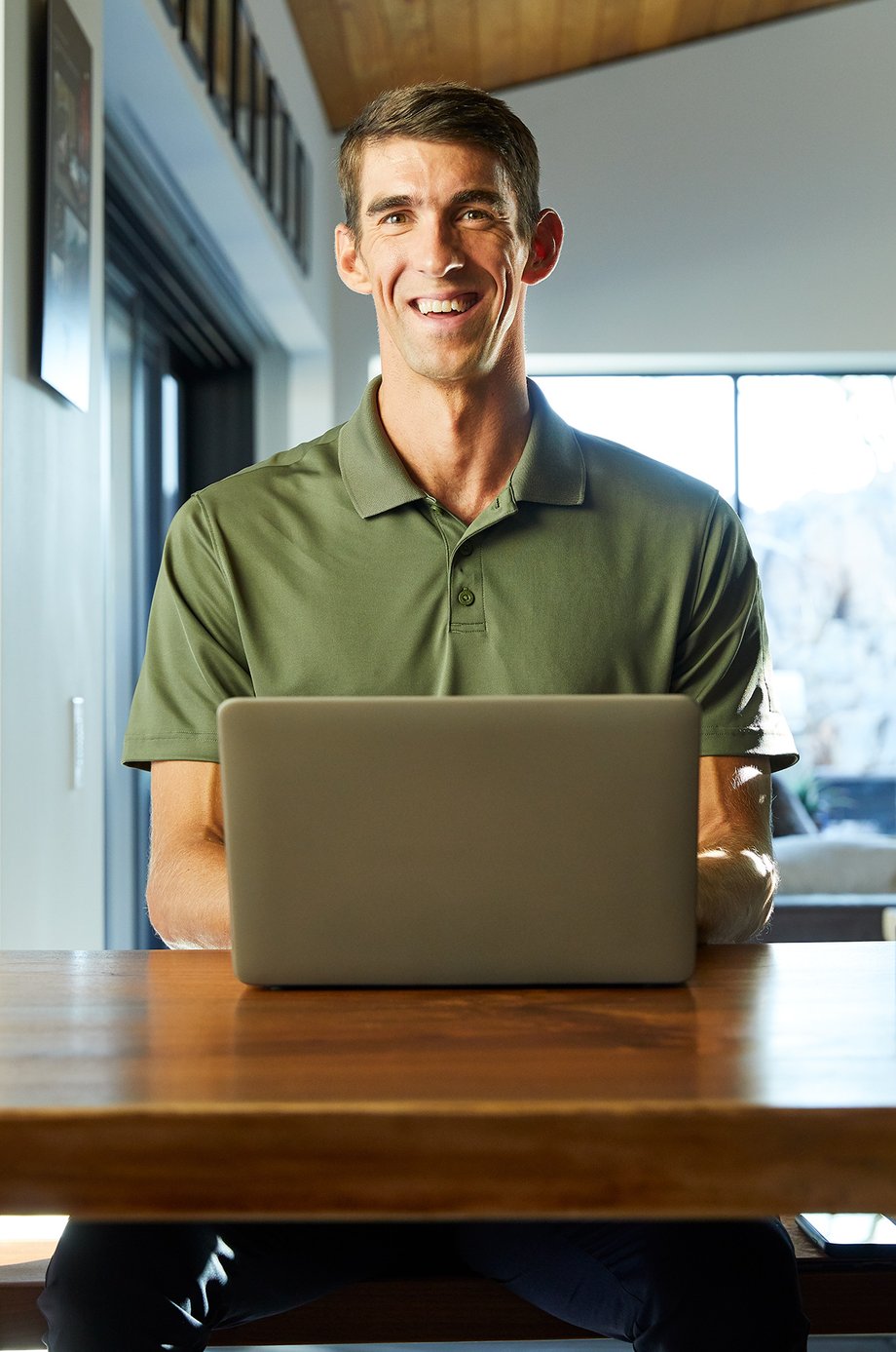Photograph of Michael Phelps behind a laptop.