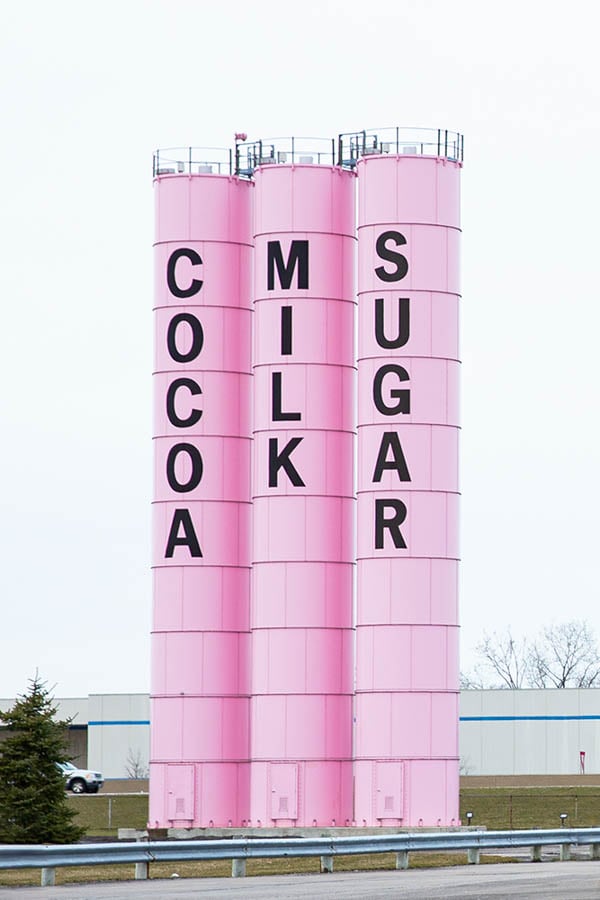 Three big pink cylinder storage facilities with the words, "Cocoa", "Milk" and, "Sugar" written down the side in black lettering by photographer Steve Craft of Phoenix, Arizona. 