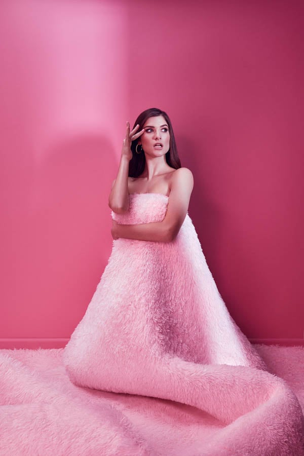 A model dressed in a fuzzy pink blanket in front of a pink backdrop by photographer Stevie Chris of Philadelphia, PA.