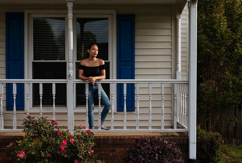 Will Crooks captures a young woman standing on her front porch in front of a rose bush