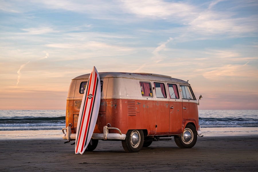 A VW bug parked on the beach with a surfboard resting on it by photographer Aaron Ingrao of Buffalo, New York.