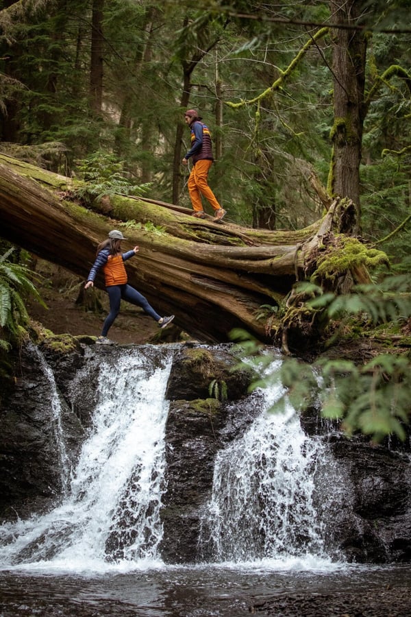 Photo of two figures standing by a waterfall and fallen sequoia by San Francisco, California-based photographer Adam Wells.