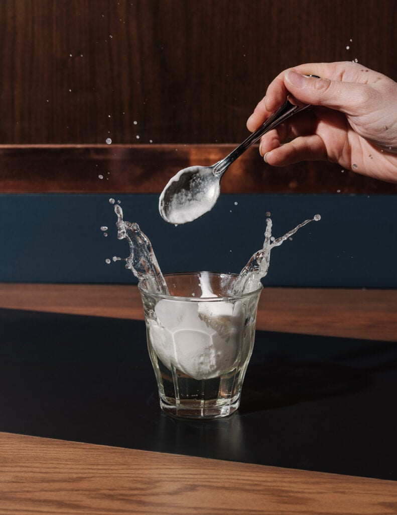 Something being dropped into a cocktail glass by photographer Andrew Thomas Lee of Atlanta, Georgia