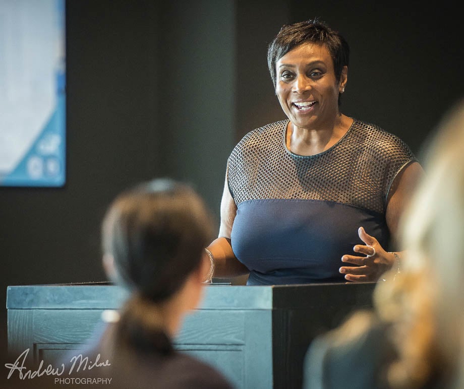 Photo of an African American woman speaking at a conference or seminar taken by Miami-based corporate photographer Andy Milne. 