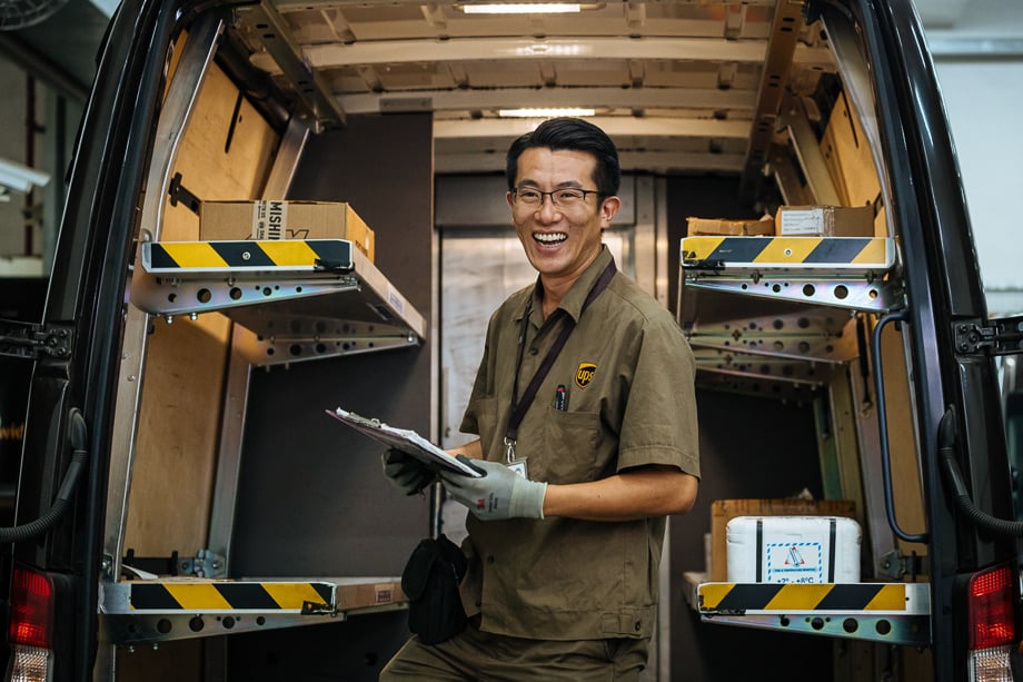 Photo of an Asian UPS deliveryman outside his van taken by Atlanta-based industrial photographer Audra Melton. 