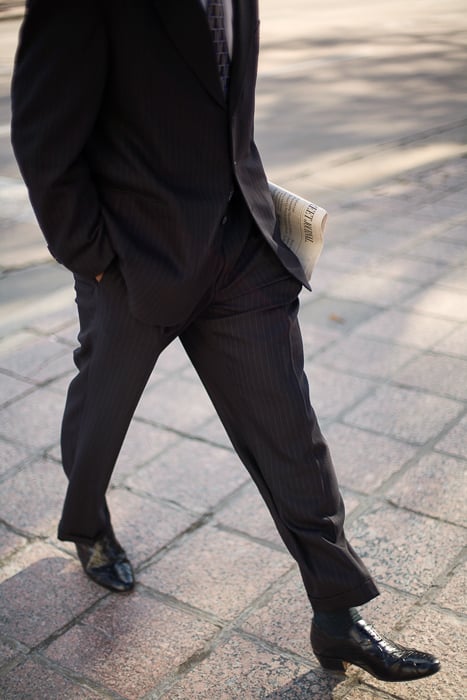 Photo of a businessman walking outdoors with a copy of the Wall Street Journal in hand taken by Washington DC-based corporate photographer Bob Rives. 