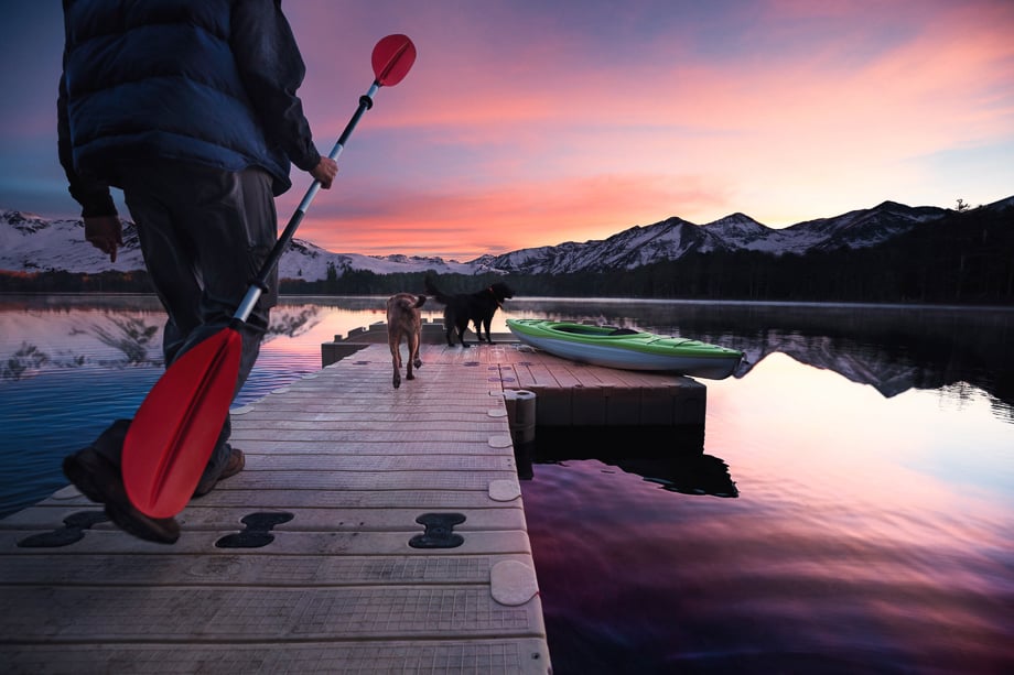 Photo of a man and his two dogs about to go paddle boarding in a lake taken by Washington DC-based lifestyle photographer Clark Vandergrift. 
