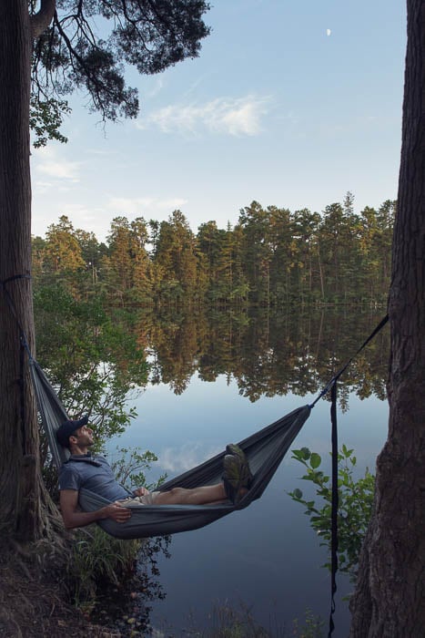 Photo of a man resting on an outdoor hammock by the lake taken by Philadelphia-based lifestyle photographer Colin M. Lenton. 