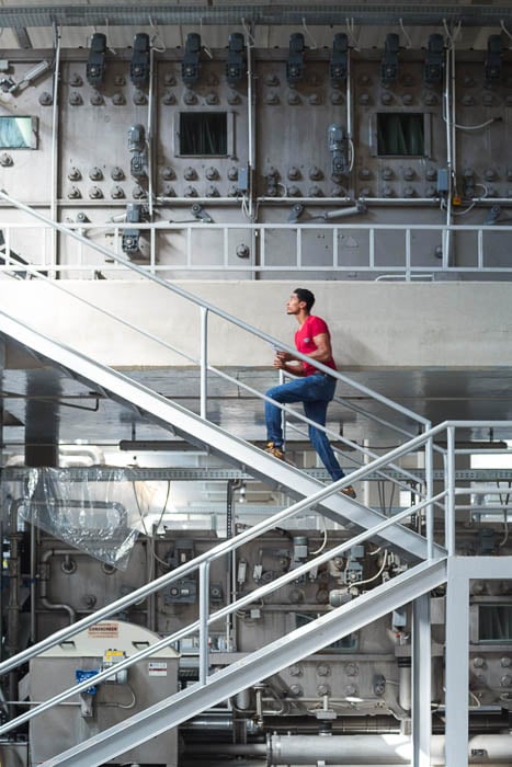 A photo of a man climbing stairs in a factory taken by New York-based industrial photographer David Degner. 