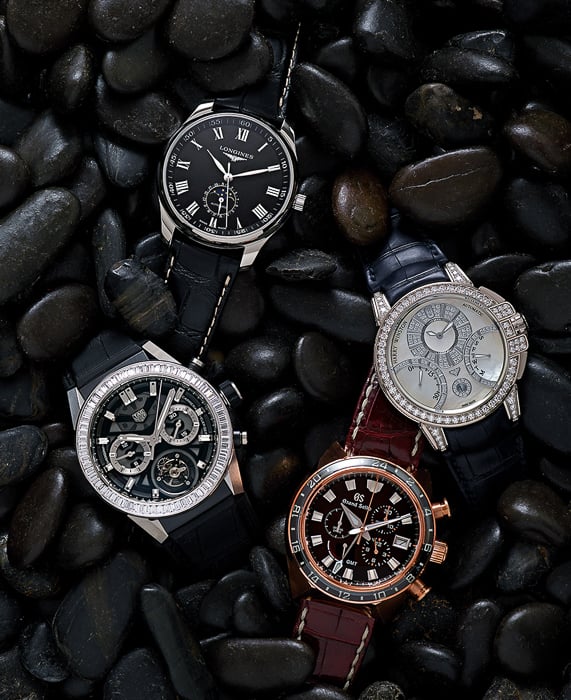 Photo of Longines, Tag Heuer, Harry Winston, and Grand Seiko watches resting on polished stone pebbles taken by New York-based product photographer David Lewis Taylor. 